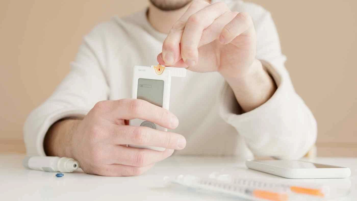 A blood glucose meter beside fresh vegetables
