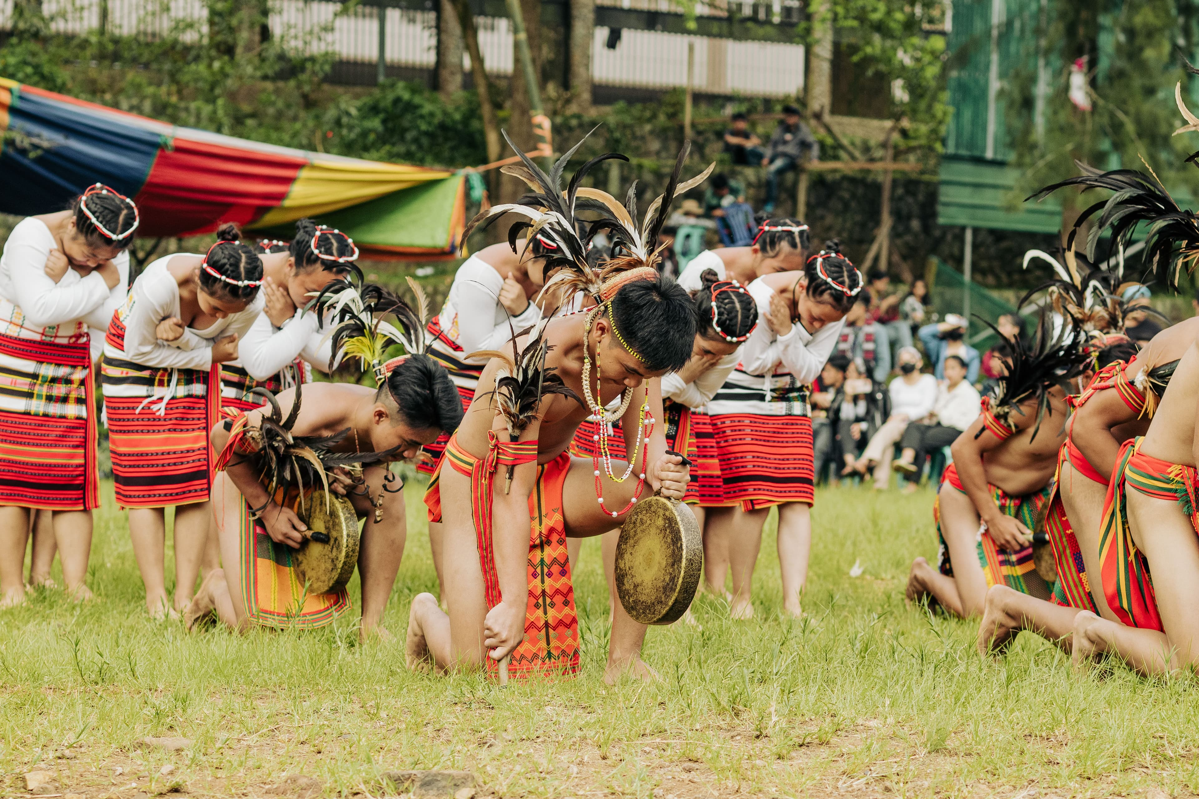 Group of indigenous dancers performing a traditional dance outdoors in colorful attire