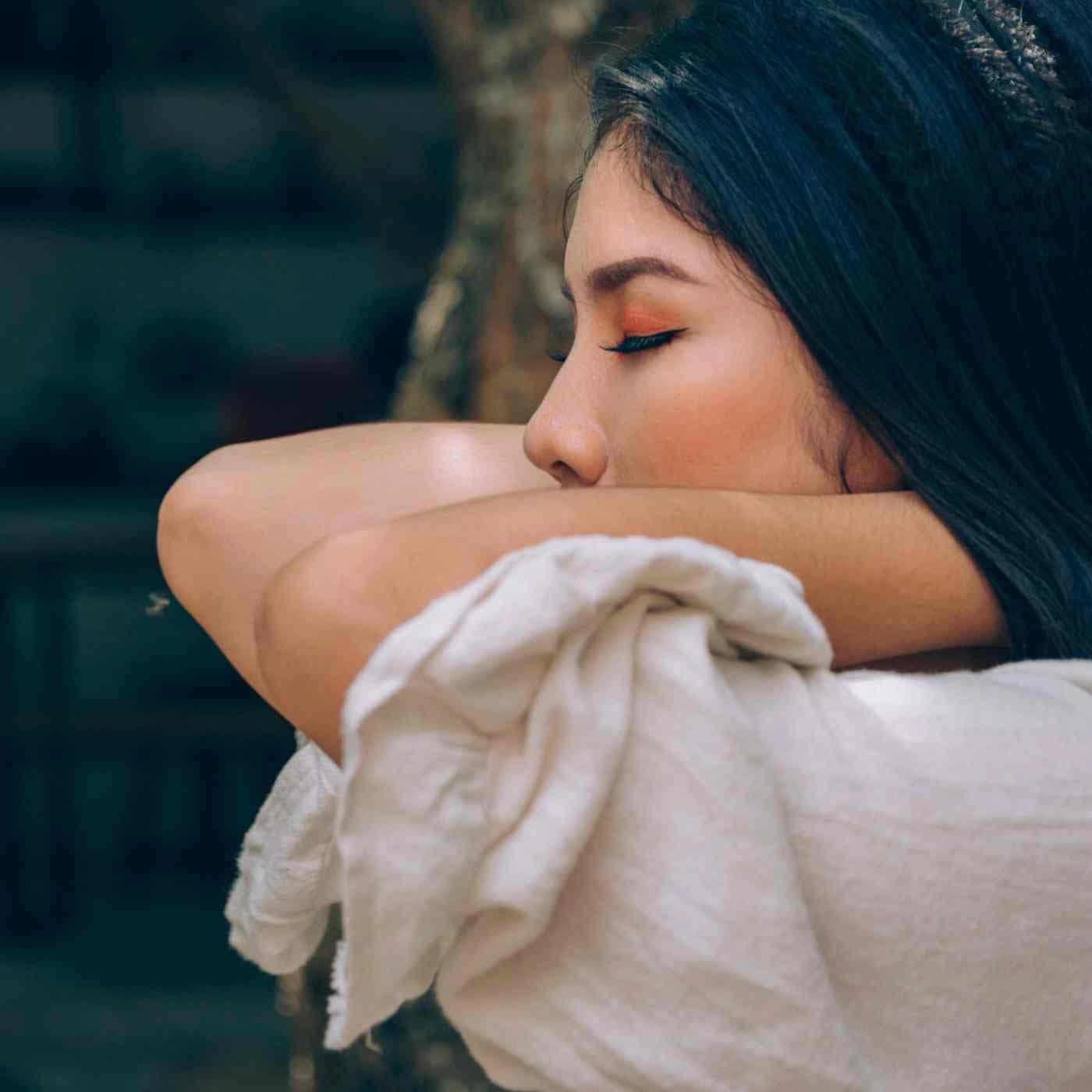 A person resting quietly with a hand at the shoulder