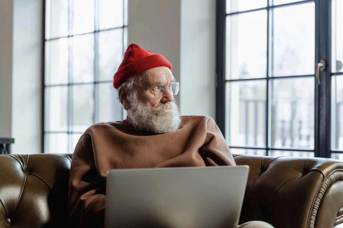 An older person sitting calmly beside a window